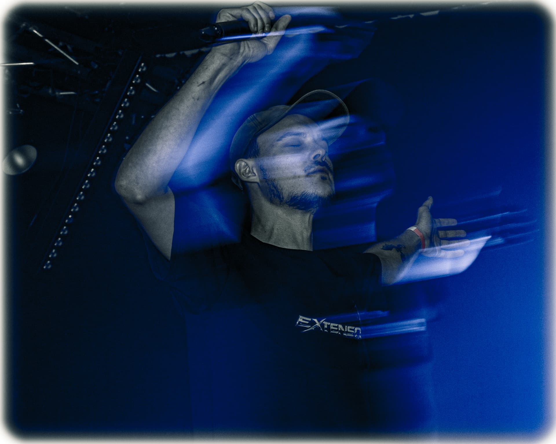 EXTENSO artist performing under a single spotlight